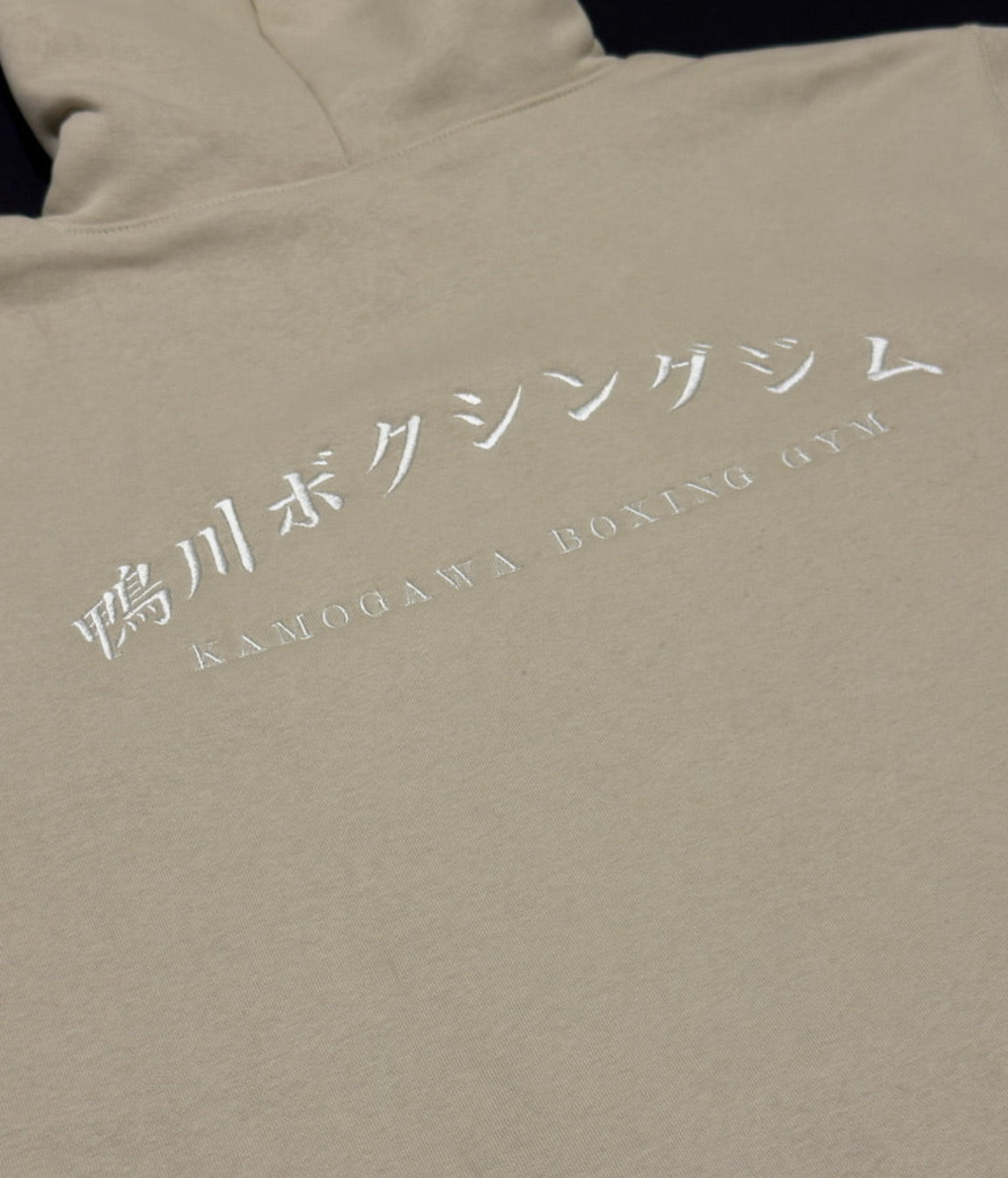 Bone hoodie with white text on a beige background