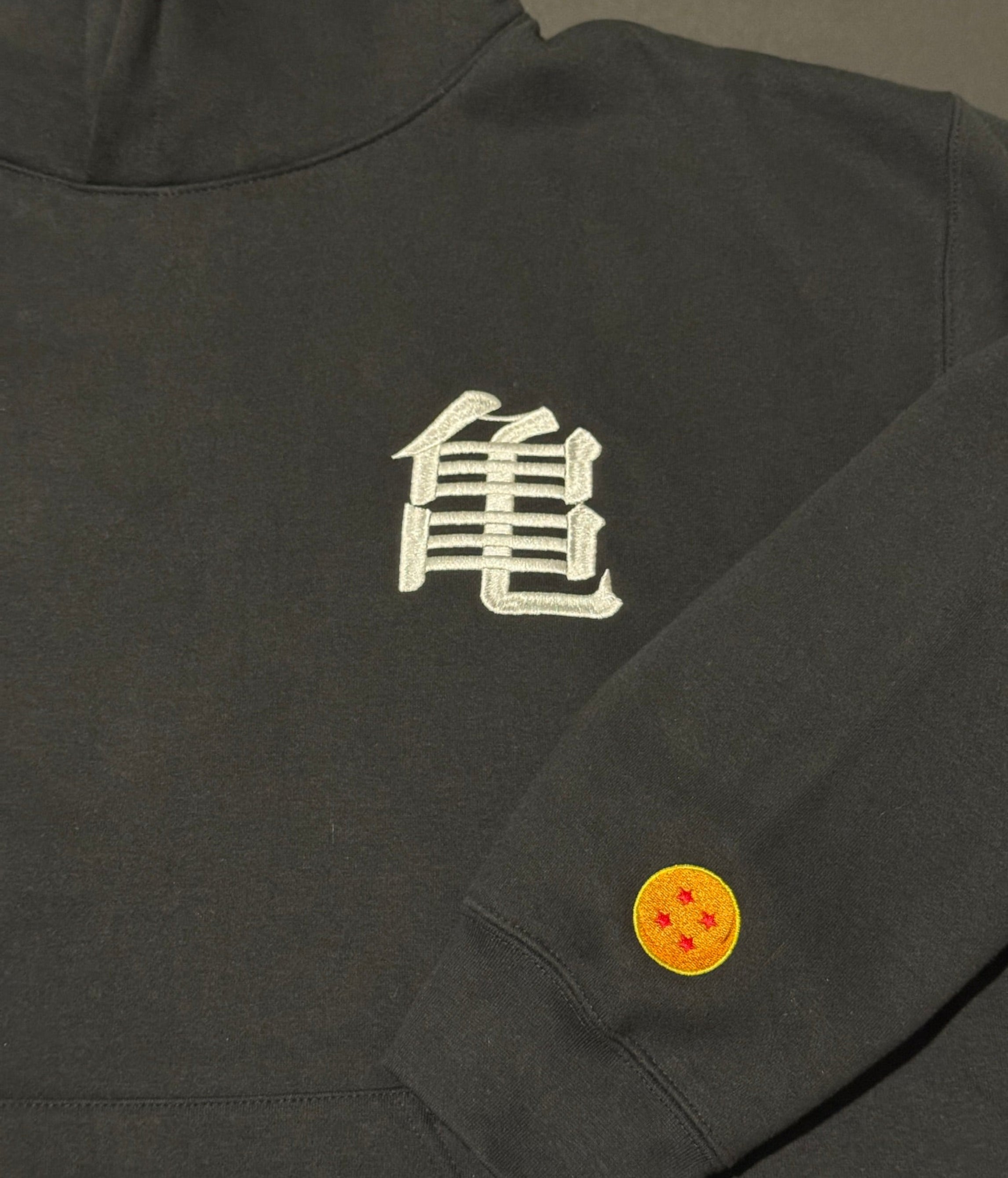 Black hoodie with a 'Kame' logo on the chest and Dragonball on sleeve