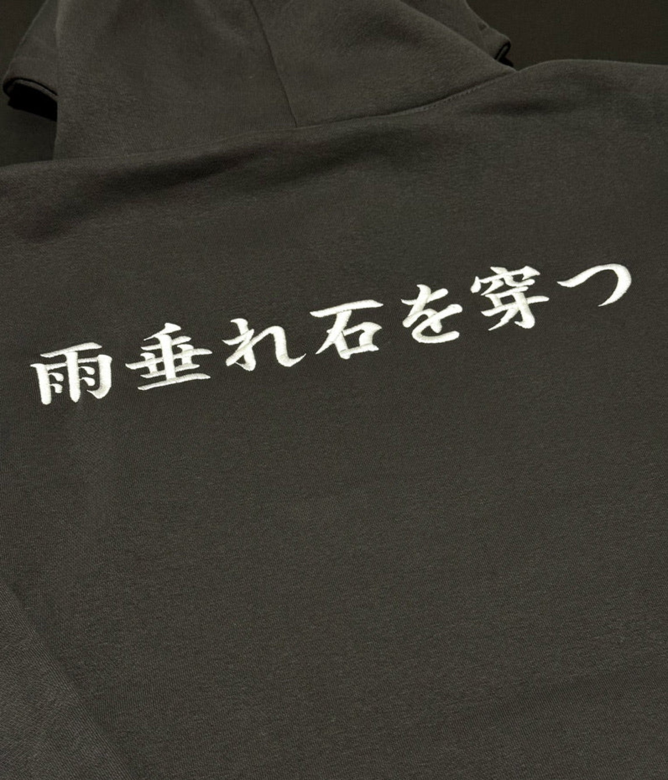 Shadow hoodie with 'Amadare ishi o ugatsu' on the back