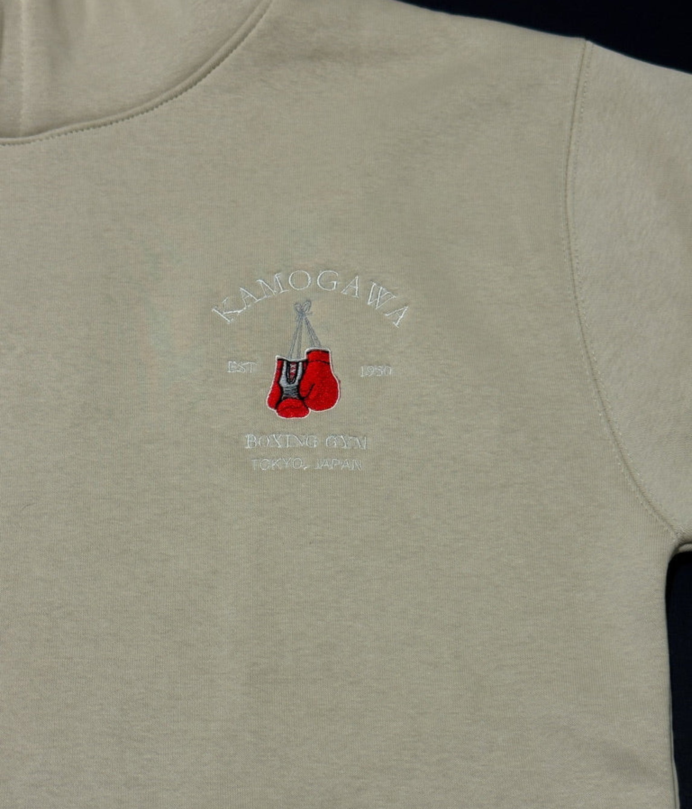 Bone hoodie with boxing gloves and text on the chest.