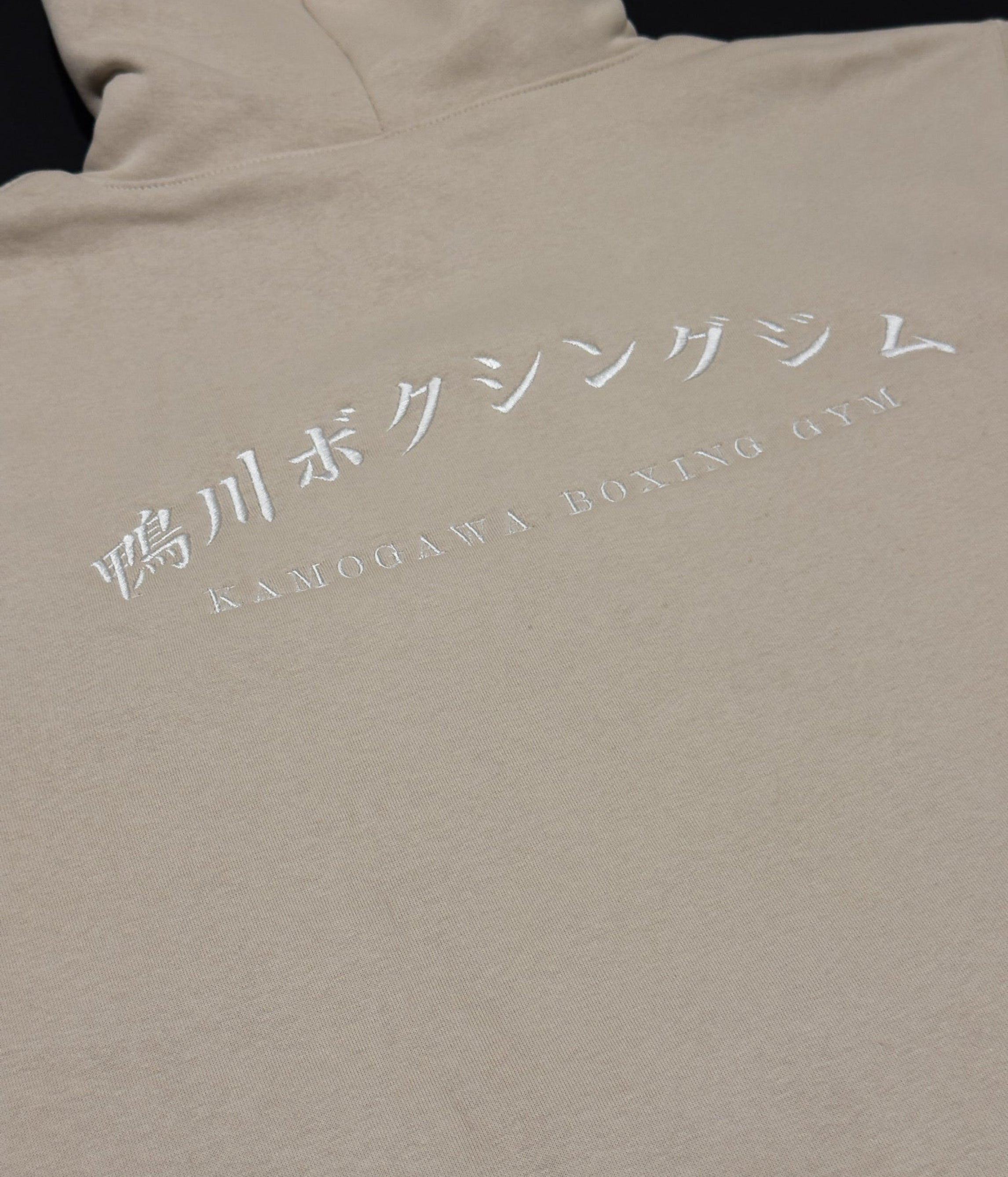 Bone hoodie with 'Kamogawa Bokushingu Jimu' on the back