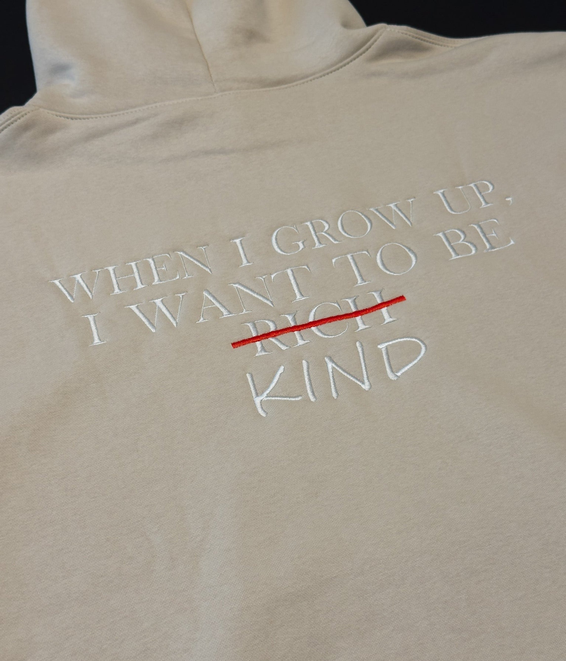 Bone hoodie with text 'WHEN I GROW UP, I WANT TO BE RICH KIND' on a black background